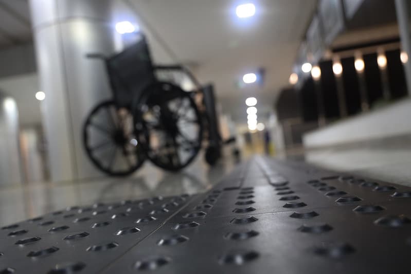 Cadeira de rodas em corredor branco, semelhante ao de um hospital
