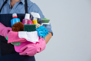 trabalhadora com produtos de limpeza em mãos