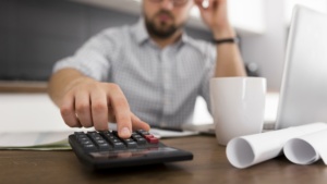 homem fazendo contas na calculadora