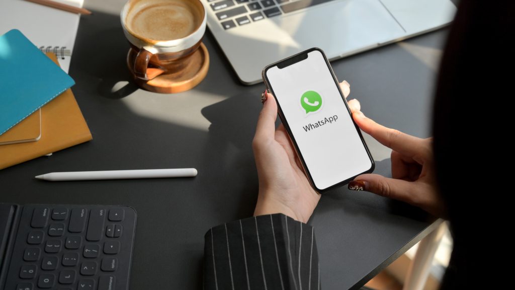 mulher olhando para tela de celular com whatsapp