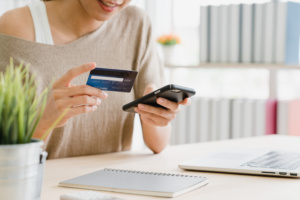 Mulher utilizando cartão de crédito para fazer compras pessoais.