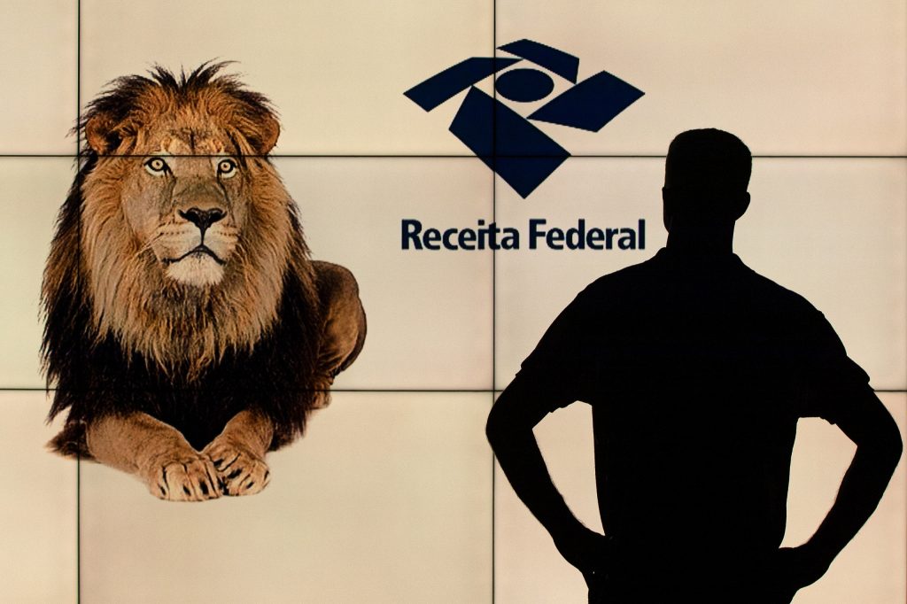 telão da receita federal e homem em contra luz