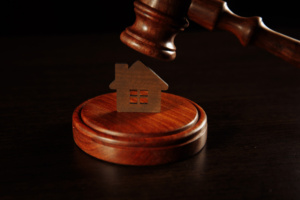 Miniatura de casa sobre suporte de martelo de juiz