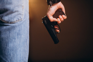 pessoa segurando arma de fogo