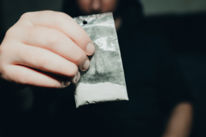 homem segurando pacote com cocaína