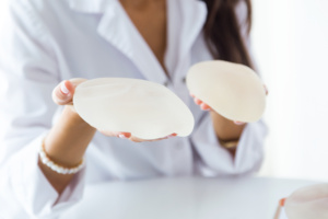 médica segurando proteses mamárias
