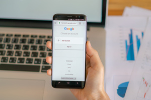 pessoa com celular na mão; tela mostra o Google