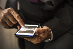 homem de terno vendo foto em celular