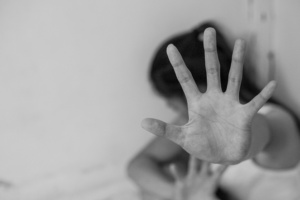 mulher no chão se protegendo de agressão