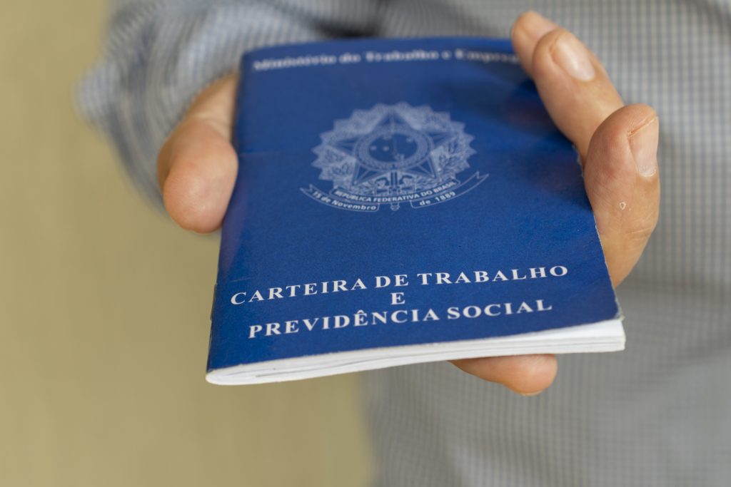 homem entregando carteira de trabalho brasileira