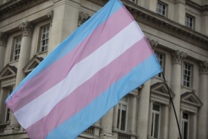 bandeira trans em frente a um prédio