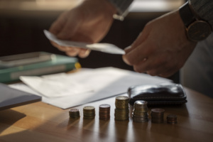 homem contando moedas e papéis sobre a mesa