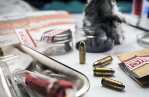 close up em mesa com projéteis e pastas de investigação