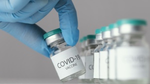 enfermeiro pegando frasco de vacina da covid