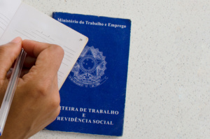 homem assinando carteiras de trabalho