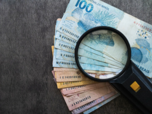 notas de reais e lupa