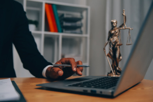 homem em escritório com estátua da justiça ao lado