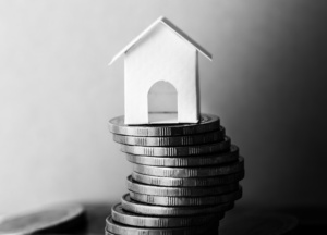 casa de papel sobre pilha de moedas em preto e branco