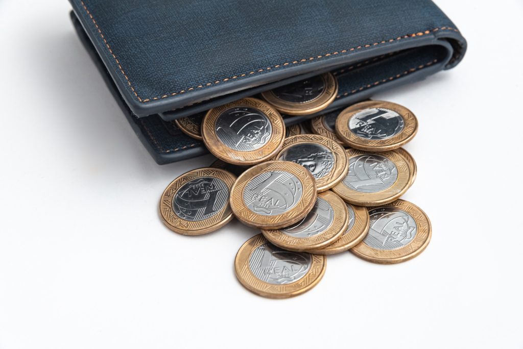 moedas de 1 real saindo de uma carteira