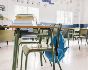 carteira com livros e mochila; sala de aula